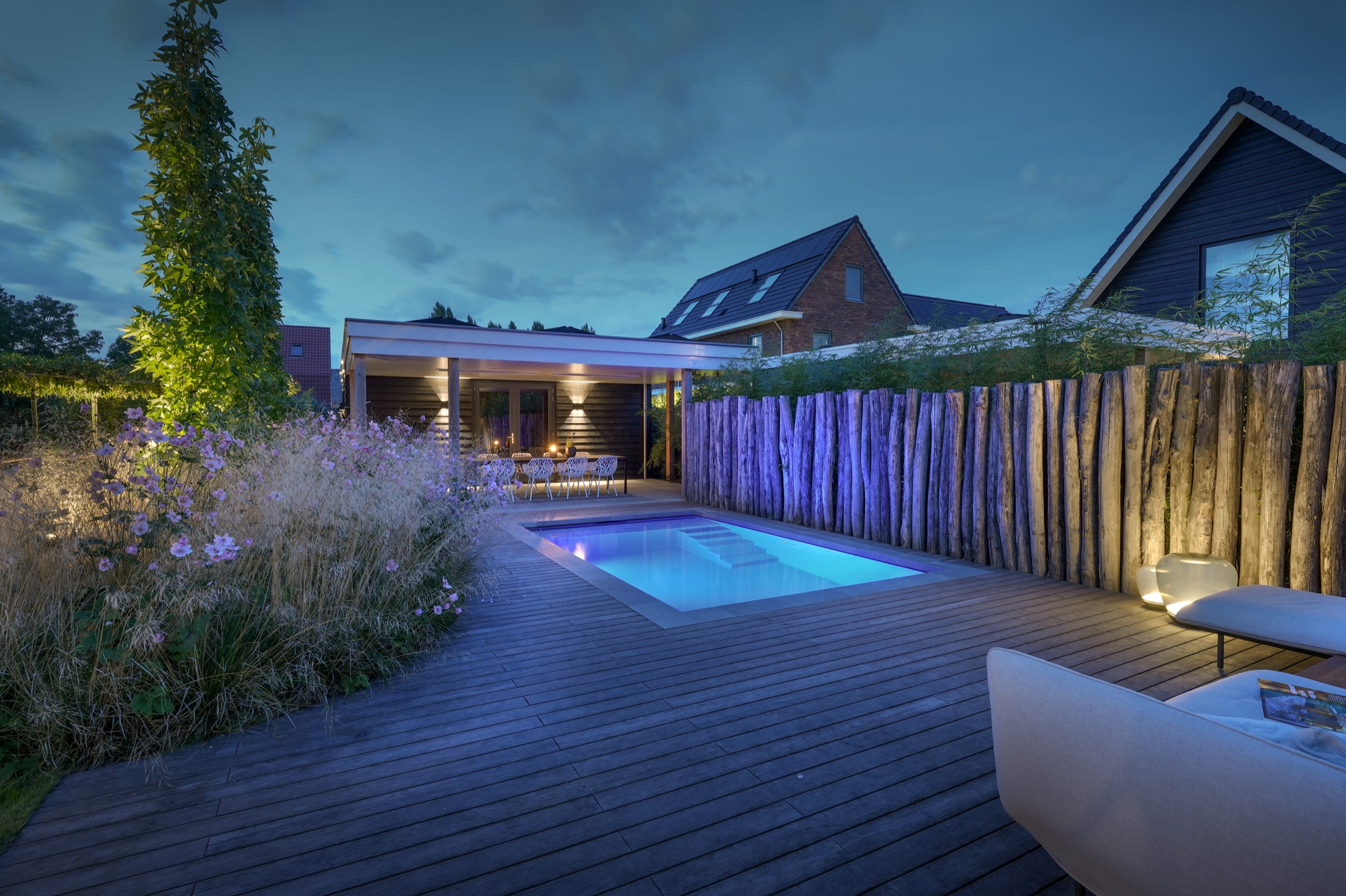 Tuin met zwembad en sfeerverlichting in de avond
